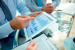 6-EE3_visuel2_homme-d'affaires-montrant-tablette-avec-données-en-graphiques